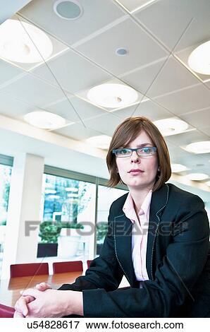 Stock Photo - Businesswoman sitting in office. Fotosearch
