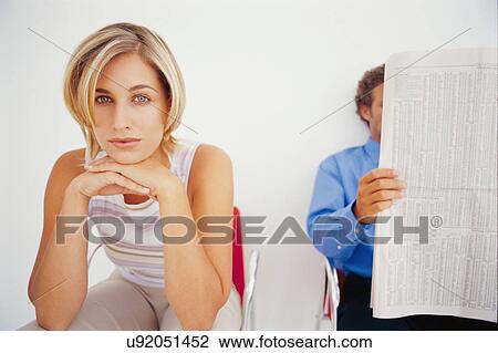 Stock Image - Businesswoman sitting in waiting area. Fotosearch