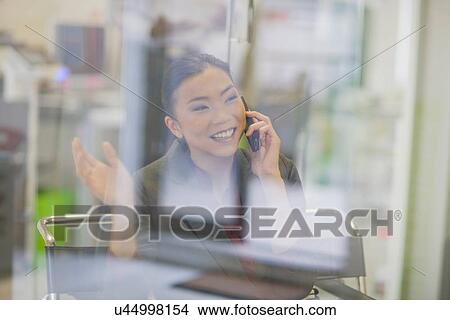 Picture - Businesswoman talking on cell phone. Fotosearch