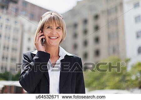 Stock Image - Businesswoman talking on cell phone. Fotosearch