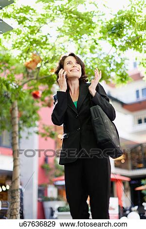 Stock Photo - Businesswoman talking on cell phone. Fotosearch