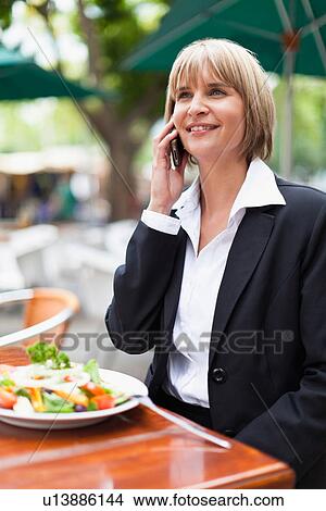 Businesswoman talking on phone at lunch View Large Photo Image Picture - Businesswoman talking on phone at lunch. Fotosearch