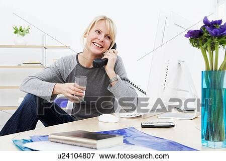 Stock Photo - Businesswoman talking on phone at work. Fotosearch