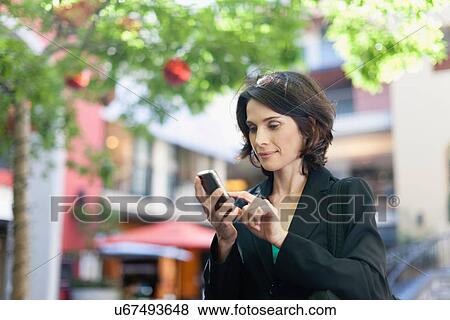 Businesswoman using cell phone outdoors View Large Photo Image Stock Photo - Businesswoman using cell phone outdoors. Fotosearch