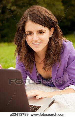 Businesswoman using laptop in park View Large Photo Image Stock Photo - Businesswoman using laptop in park. Fotosearch