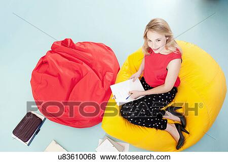 Stock Photo - Businesswoman working in bean bag chair. Fotosearch