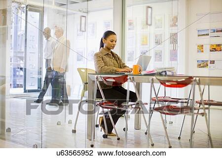 Businesswoman working on laptop at desk View Large Photo Image Stock Image - Businesswoman working on laptop at desk. Fotosearch