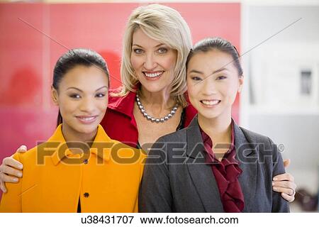 Businesswomen smiling in office View Large Photo Image Stock Photo - Businesswomen smiling in office. Fotosearch