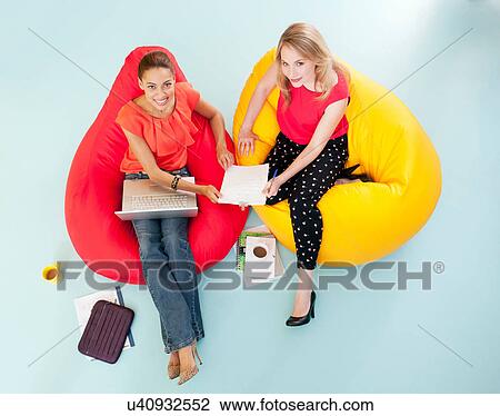 Businesswomen working in bean bag chairs View Large Photo Image Stock Image - Businesswomen working in bean bag chairs. Fotosearch
