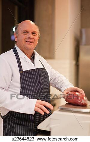 Stock Image - Butcher holding piece of meat. Fotosearch