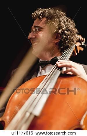 Cello player in orchestra View Large Photo Image Stock Photograph - Cello player in orchestra. Fotosearch