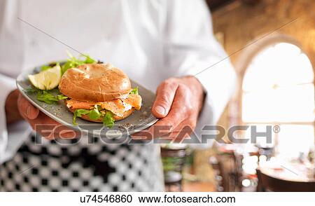 Chef holding bagel with Scottish smoked salmon and cream cheese View Large Photo Image Stock Image - Chef holding bagel with Scottish smoked salmon and cream cheese. Fotosearch