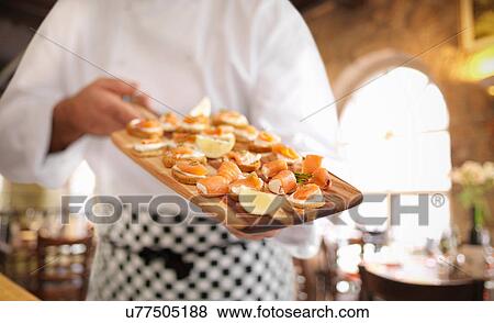 Chef holding board of Scottish smoked salmon and cream cheese canapes View Large Photo Image Stock Photo - Chef holding board of Scottish smoked salmon and cream cheese canapes. Fotosearch