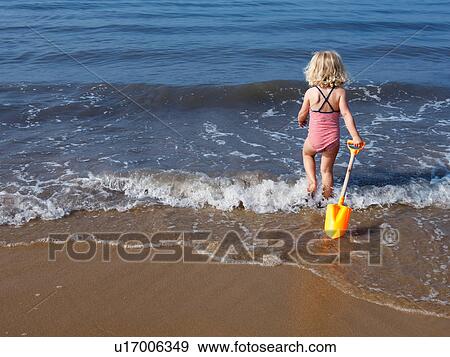 Child playing in water at beach View Large Photo Image Stock Photo - Child playing in water at beach. Fotosearch