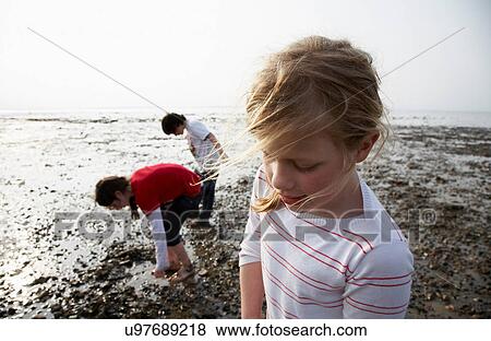 Stock Photo - Children playing on rocky beach. Fotosearch