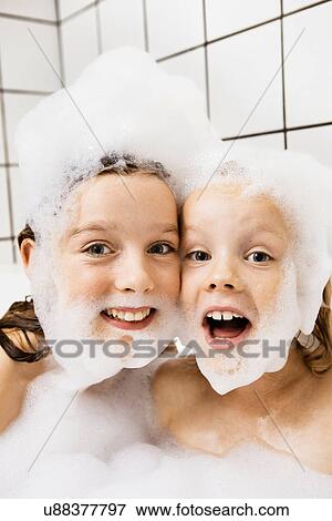 Stock Photo - Children playing with bubbles in bath. Fotosearch