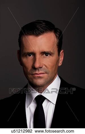 Stock Image - Close up of businessman's frowning face. Fotosearch