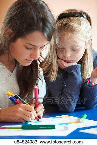 Stock Image - Close up of children drawing indoors. Fotosearch