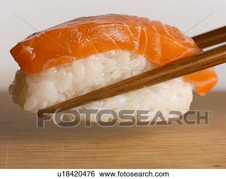 Close up of chopsticks holding sushi View Large Photo Image Stock Photograph - Close up of chopsticks holding sushi. Fotosearch