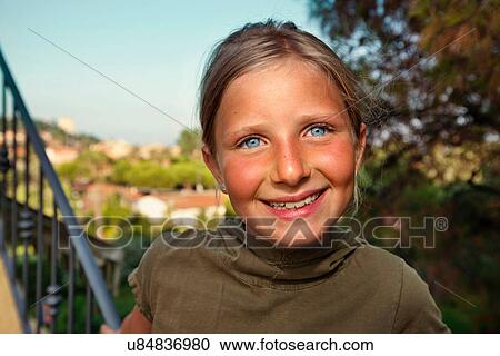 Stock Image - Close up of girl's smiling face. Fotosearch