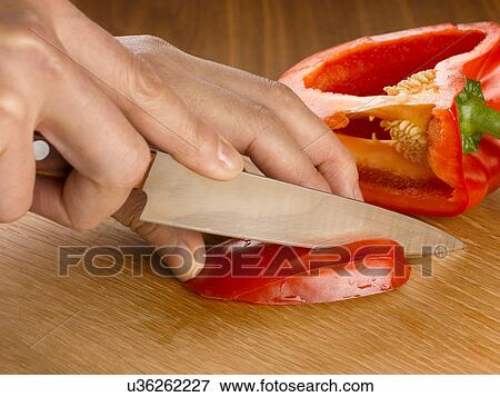 Stock Photo - Close up of hands cutting bell pepper. Fotosearch