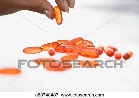 Stock Photo - Close up of woman counting pills. Fotosearch