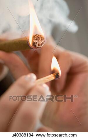 Picture - Close up of woman lighting cigarette. Fotosearch