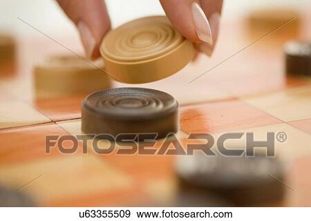 Stock Photo - Close up of woman playing checkers. Fotosearch