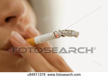Stock Photo - Close up of woman smoking cigarette. Fotosearch
