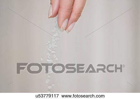 Stock Photo - Close up of woman sprinkling salt. Fotosearch