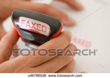 Stock Photograph - Close up of woman stamping faxed. Fotosearch