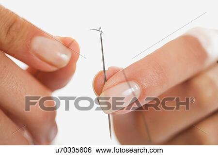 Close up of woman threading needle View Large Photo Image Stock Photograph - Close up of woman threading needle. Fotosearch
