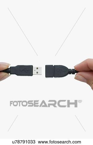 Stock Image - Close up of woman using USB cord. Fotosearch