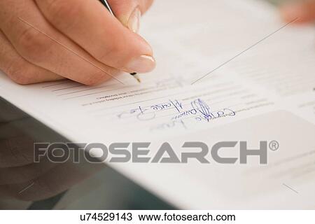 Stock Image - Close up of woman writing. Fotosearch
