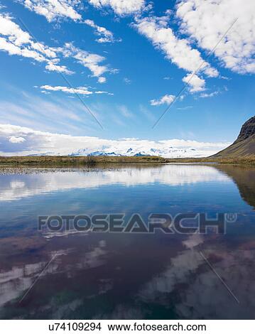 Clouds and mountains reflected in lake View Large Photo Image Picture - Clouds and mountains reflected in lake. Fotosearch