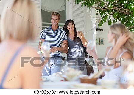 Stock Photo - Couple arriving to dinner party. Fotosearch