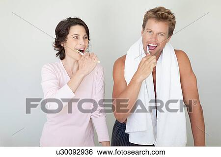 Couple brushing their teeth in bathroom View Large Photo Image Stock Photograph - Couple brushing their teeth in bathroom. Fotosearch