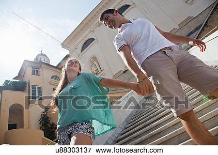 Couple climbing steps of ornate building View Large Photo Image Stock Photo - Couple climbing steps of ornate building. Fotosearch
