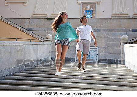 Stock Photography - Couple climbing steps of ornate building. Fotosearch