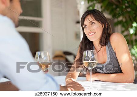 Couple having wine at table outdoors View Large Photo Image Stock Image - Couple having wine at table outdoors. Fotosearch
