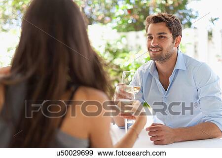 Couple having wine at table outdoors View Large Photo Image Stock Photo - Couple having wine at table outdoors. Fotosearch