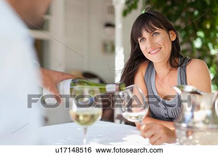 Couple having wine at table outdoors View Large Photo Image Stock Photograph - Couple having wine at table outdoors. Fotosearch