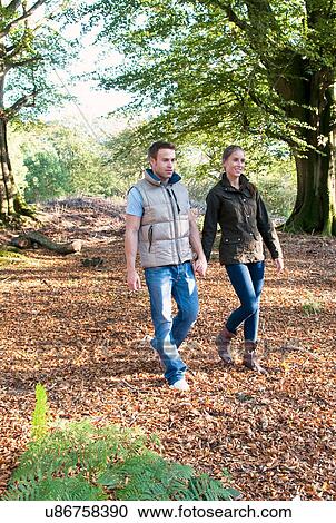 Stock Image - Couple holding hands in park. Fotosearch