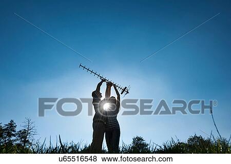 Stock Photo - Couple holding up antenna outdoors. Fotosearch