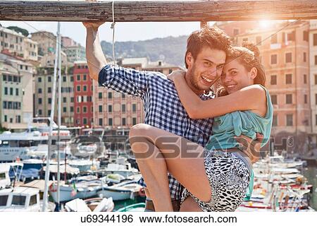 Stock Photograph - Couple hugging by urban pier. Fotosearch