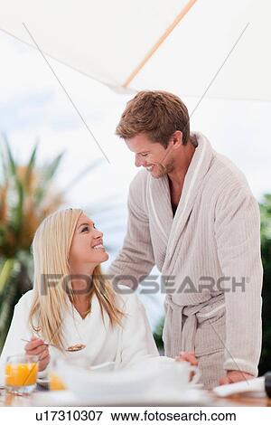 Stock Photo - Couple in bathrobes having breakfast. Fotosearch