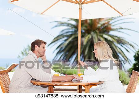 Stock Photography - Couple in bathrobes having breakfast. Fotosearch