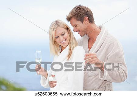 Stock Photography - Couple in bathrobes hugging outdoors. Fotosearch
