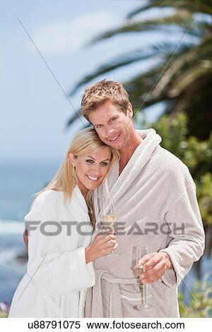 Stock Photography - Couple in bathrobes hugging outdoors. Fotosearch