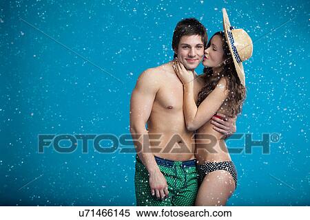 Stock Photography - Couple in swimsuits hugging in snow. Fotosearch